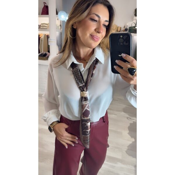 Camisa blanca semi transparente cuello camisero y detalle de pañuelo estampado con broche